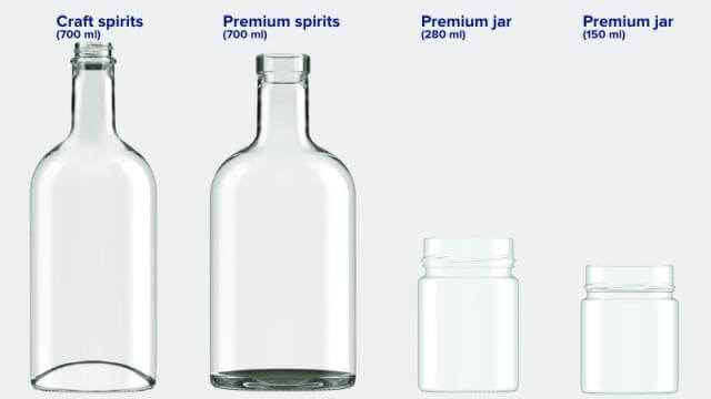 Two clear glass spirit bottles and two clear glass jars in a row