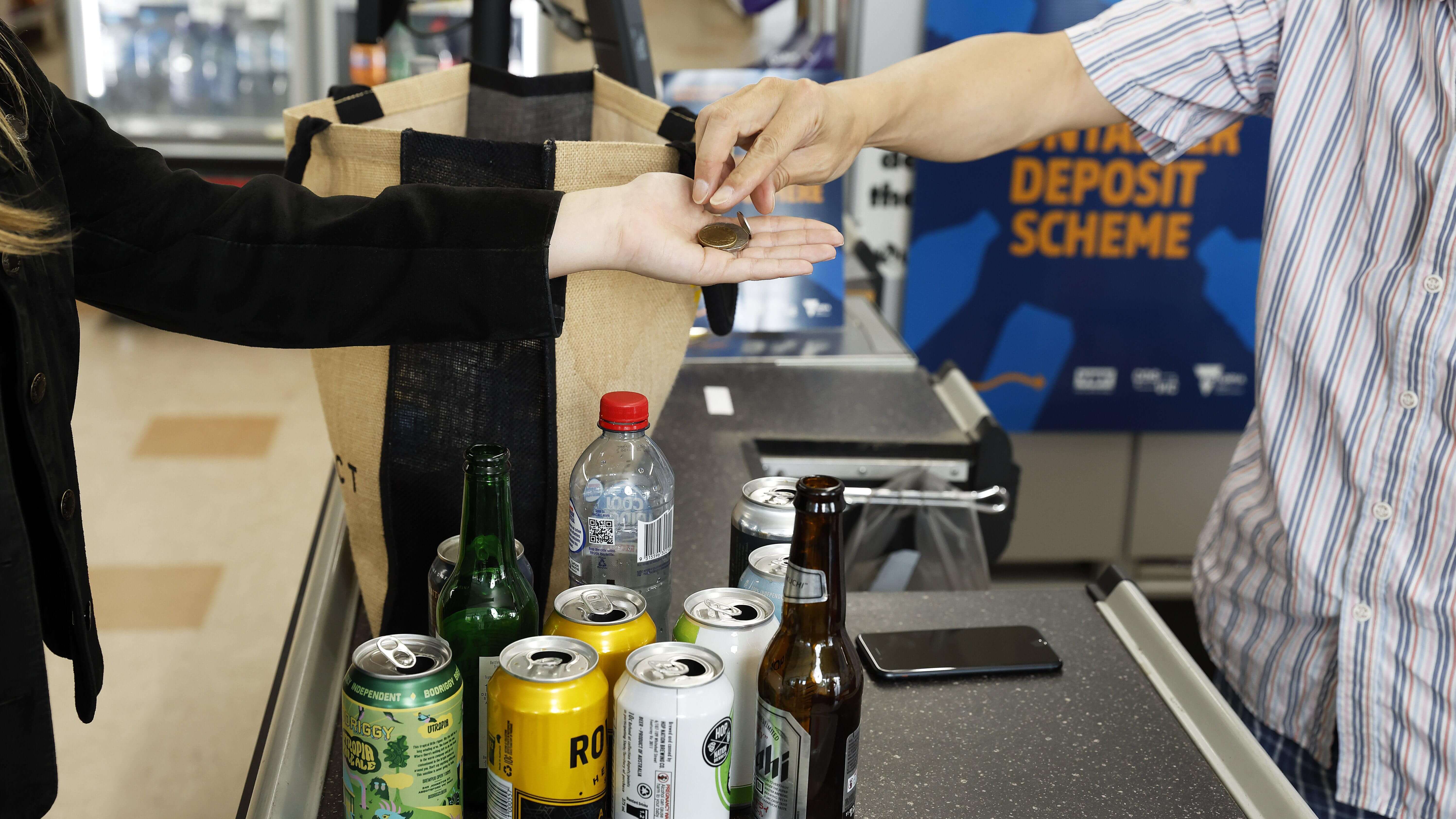 Two people exchanging coins for drink packaging